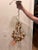 Charming Italian chandelier featuring a classic silhouette with elegant crystal accents and a warm patinated metal frame....