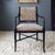 A stunning pair of French Directoire-style armchairs features faux bamboo wooden frames painted in high gloss black, with...