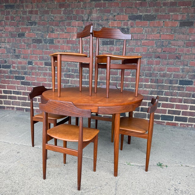 Exceptional Danish Modern teak dining set designed by Hans Olsen, featuring his ingenious space-saving chair design in...
