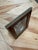 A tabletop picture frame with a glossy burgundy border and slim brass-tone trim around the outer edge and photo opening....