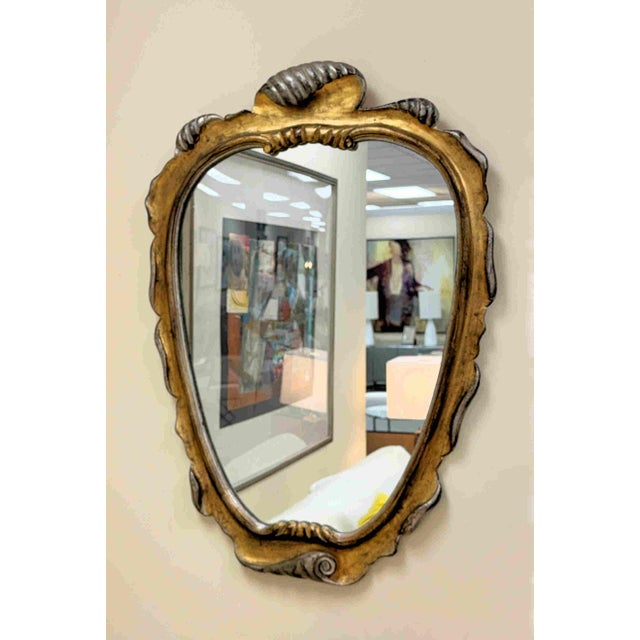 A beautiful vintage carved giltwood mirror attributed to Dorothy Draper. The distressed giltwood frame is accented with...