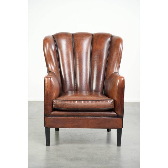 This unique sheepskin armchair features warm, deep colors, a comfortable seat, and is finished with black piping. The...