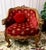 Pleased to offer a truly one-of-a-kind antique club chair fit for a king, dressed in red chenille fabric lined in studded...