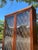 A beautiful vintage illuminated curio cabinet featuring elegant diamond pane glass doors, rich warm wood tones, and built-...