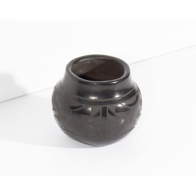 A black on black Native American pottery vase by Santa Clara pueblo pottery Cresencia Tafoya. This vessel has a geometric...