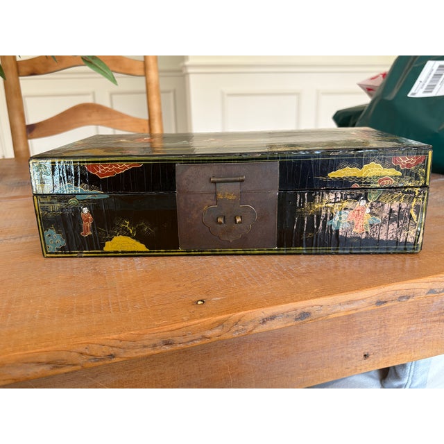 A wonderfully decorative antique Chinese lacquer box, hand-painted in polychrome with a chinoiserie scene of robed figures...
