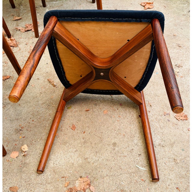 Six elegant rosewood dining chairs designed by Harry Østergaard, featuring a sculpted bentwood backrest and round tapered...