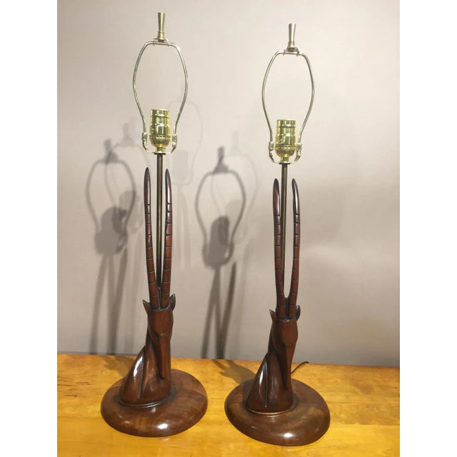 Pair of Mid-Century Carved Walnut Antelope head Lamps Dimensions: 27" from base to top of harp 18" from base to bottom of...