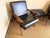 A handsome pair of mid-century style lounge chairs with matching ottoman, featuring sleek black leather upholstery and...