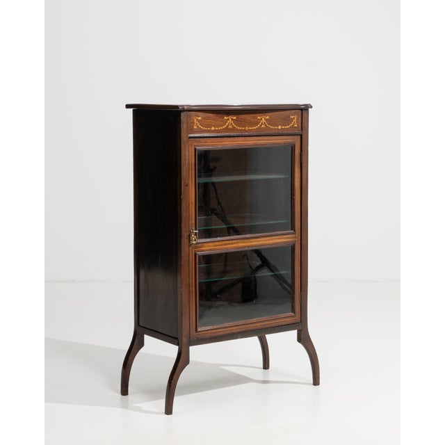 A distinguished example of Edwardian craftsmanship, this vitrine cabinet from the United Kingdom embodies the refined...
