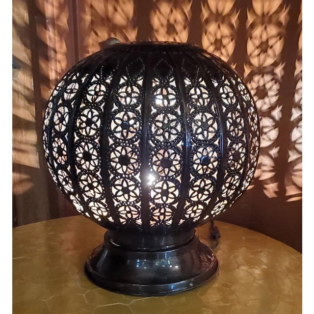 Medium size Moroccan pierced metal table lantern, Bal style, measuring approximately 13″ in height and 12" in width. A few...