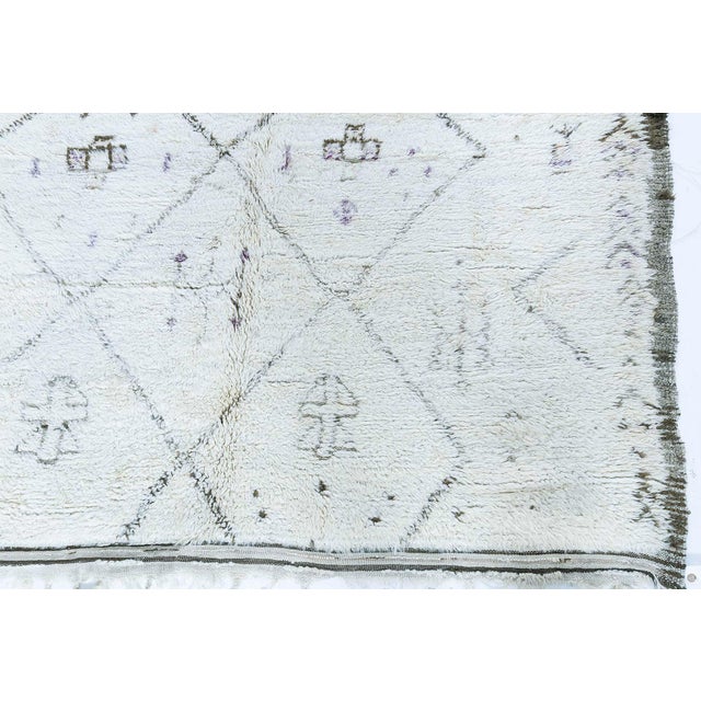 This captivating 1956 vintage Moroccan rug is a striking fusion of traditional craftsmanship and mid-century artistic...