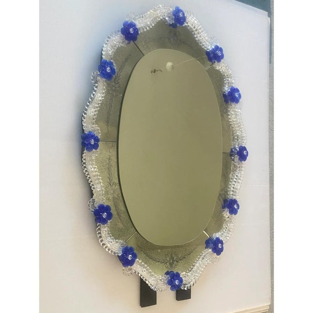 Spectacular oval mirror with Murano glass transparent elements and blue flowers. Oval mirror with venetian hand-carved...