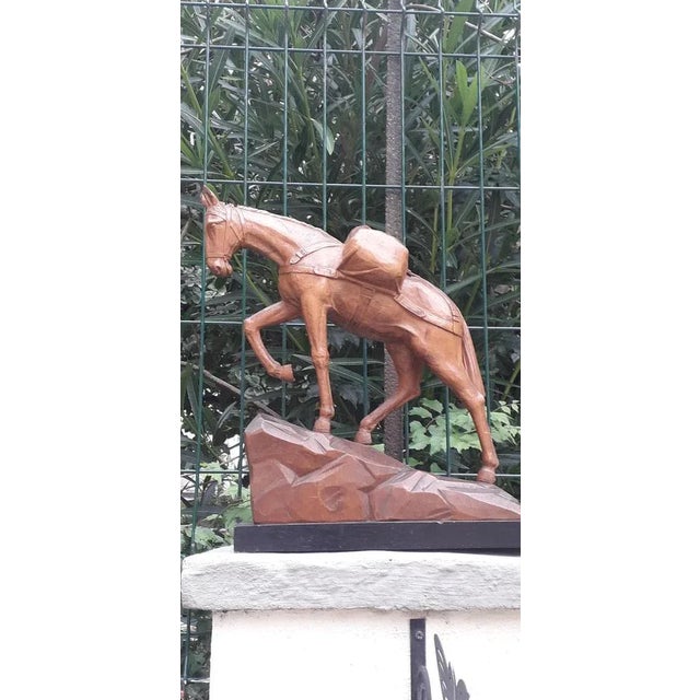 High-quality wooden sculpture depicting a horse on rocks, entirely made of wood, including the base. Significant...