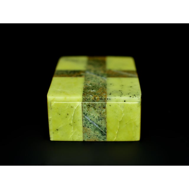 A finely crafted natural serpentine stone box, showcasing a vivid apple-green ground with subtle dark inclusions and a...