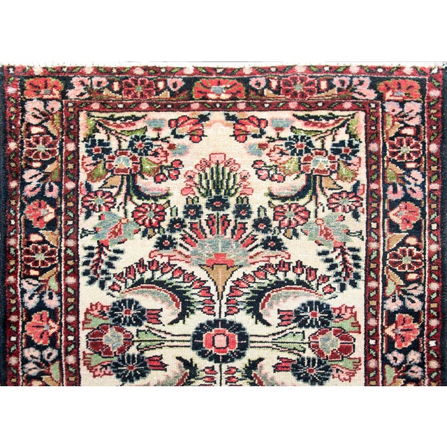 A stunning early 20th century Persian Dargazin runner with a mirrored all-over floral pattern with myriad flowers and...