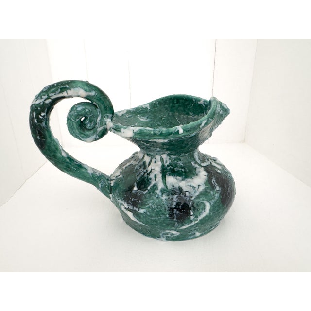 A striking vintage ceramic ewer distinguished by its expressive form and richly textured green, white and dark brown...