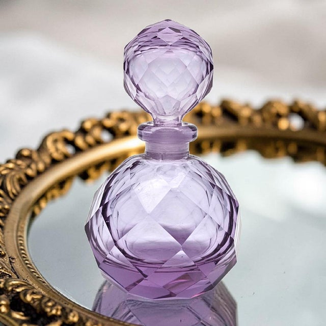 A finely executed Japanese hand-cut glass perfume bottle featuring a faceted spherical form with matching stopper. The...