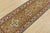 A tribal Caucasian Kazak runner hand-knotted with fine wool on a cotton foundation. This rug features geometric medallions...