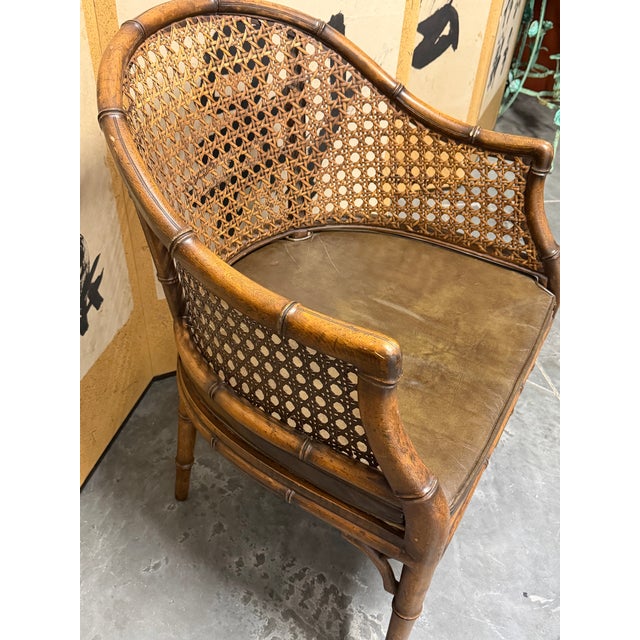 Warm chocolate colored mid-20th century Kindel Furniture (unmarked) Regency-style faux bamboo and cane barrel chair with a...