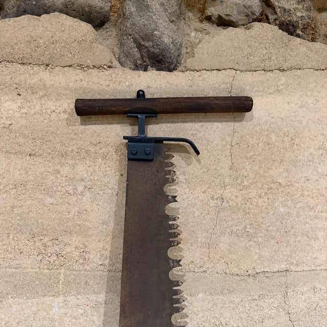 For your consideration, an antique logging tool is a two-man crosscut saw, commonly known as a "misery whip," used...