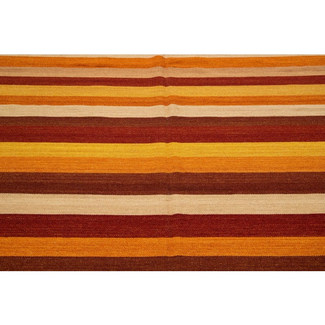 Beautiful Modern Kilim hand-knotted wool rug with multicolor accents in an all-over geometric stripe design. This rug...