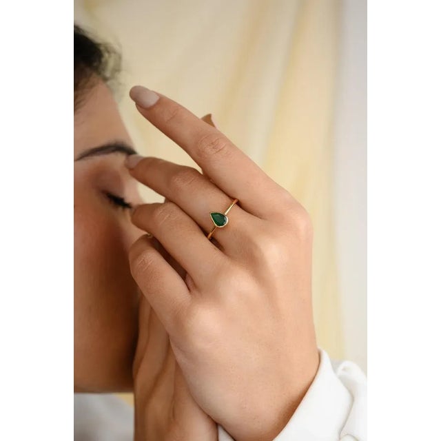 This is part of Chairish’s Fine Jewelry assortment. Pear Bezel Set Emerald Solitaire Everyday Ring in 18K Gold featuring...