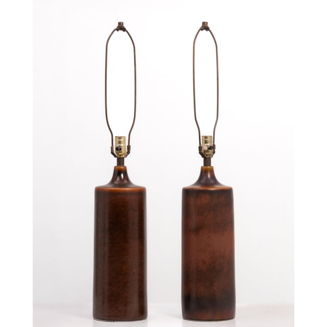 An impressive pair of Lotte and Gunnar Bostlund cylindrical table lamps with the original harps, no shades. The colors of...