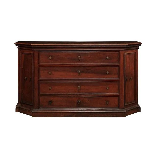 An Italian walnut dresser from the 17th century with four drawers, canted sides with doors, molded accents and rustic...