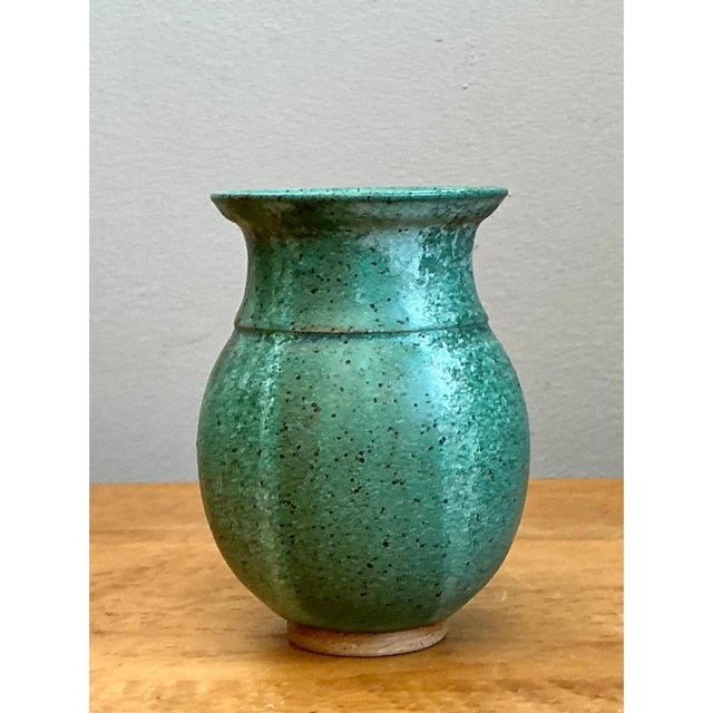 Handcrafted during the mid-20th century, this vintage studio pottery vase showcases an elegantly bulbous silhouette that...