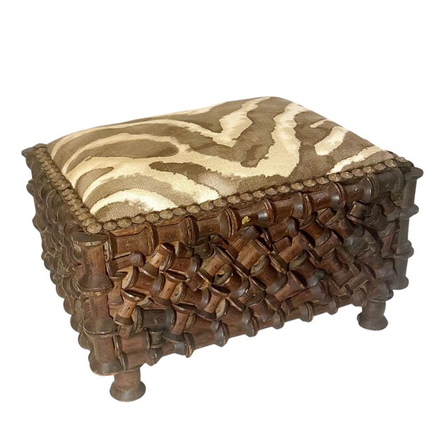 A rare and distinctive tramp art footstool, handcrafted from wooden thread spools in the early 1900s. This remarkable...
