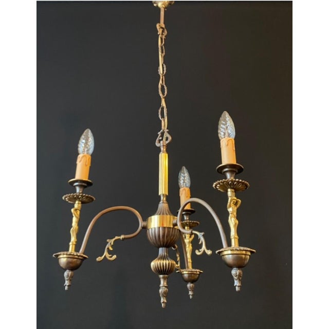 A beautiful antique chandelier. france, 20th century. the chandelier is made of brass. It is decorated with beautiful...