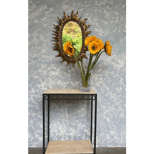 This oval gilt metal mirror offers a distinct and captivating design. The mirror features a combination of large and small...