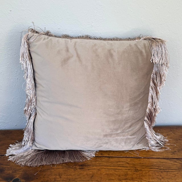 Square velveteen pillow in a soft taupe, sometimes called mushroom or oyster gray. 3.5” silky fringe in a matching shade...