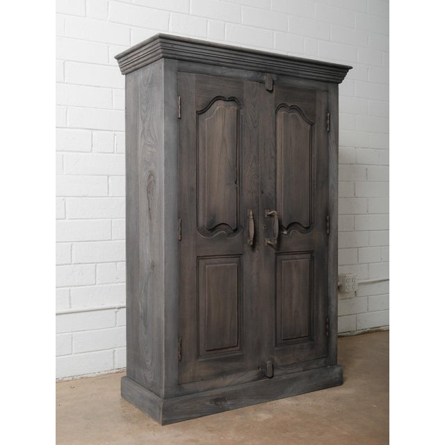 This striking wooden double-door cabinet showcases the refined craftsmanship and sculptural detailing found in 20th-...