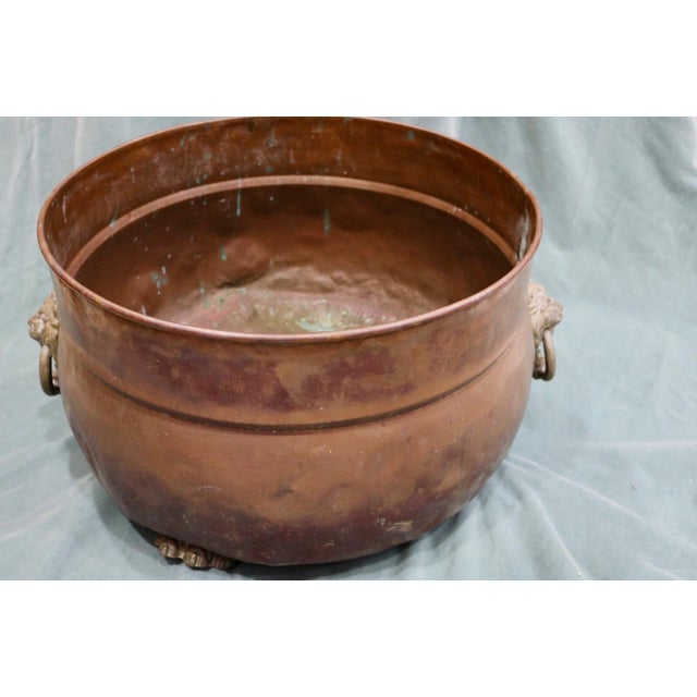 Copper Planter Pot With Brass Lion's Head Handles and Lion's Claw Feet. The pot is 19 inches in diameter at the rim 12 in...