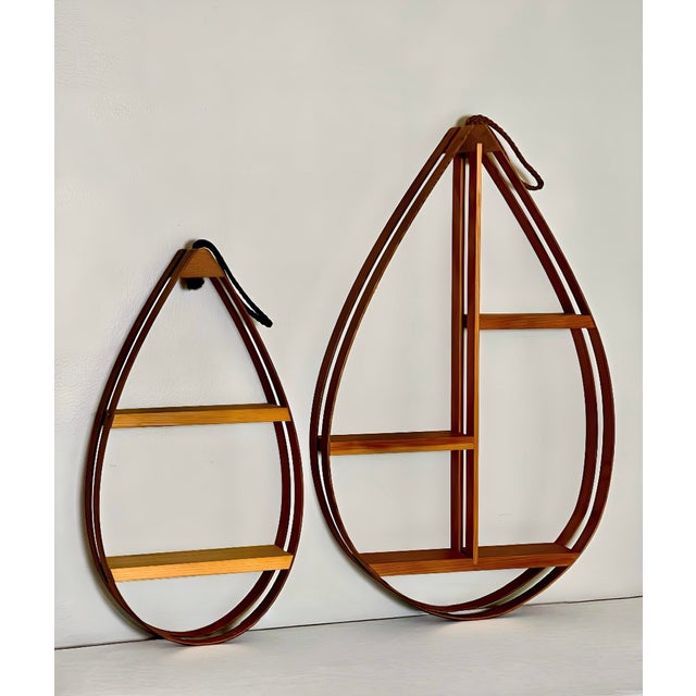 Vintage 1970s Danish modern teardrop bentwood hanging curio shelves. A coordinating pair in two sizes with a double...