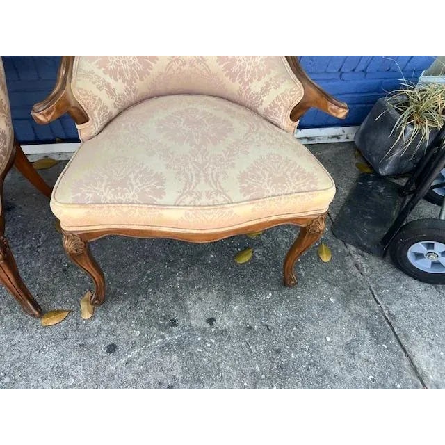 This product is a pair of French style arm chairs, made of wood and manufactured in the USA post-1950. The chairs are in a...