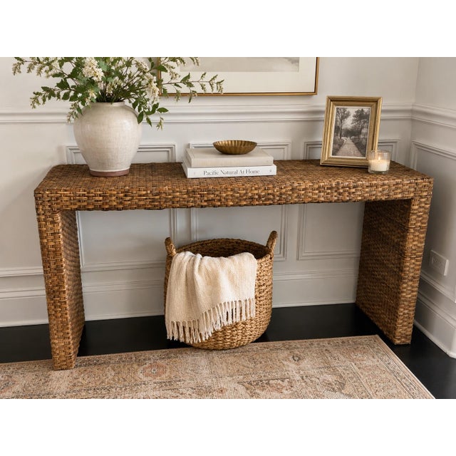 This console table is a beautifully crafted piece made from handwoven rattan by skilled artisans. This sturdy console adds...