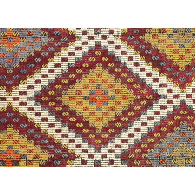 This vintage Turkish Kilim, measuring 6'5" by 10', is handwoven with wool on a wool foundation in Turkey’s Oushak region....