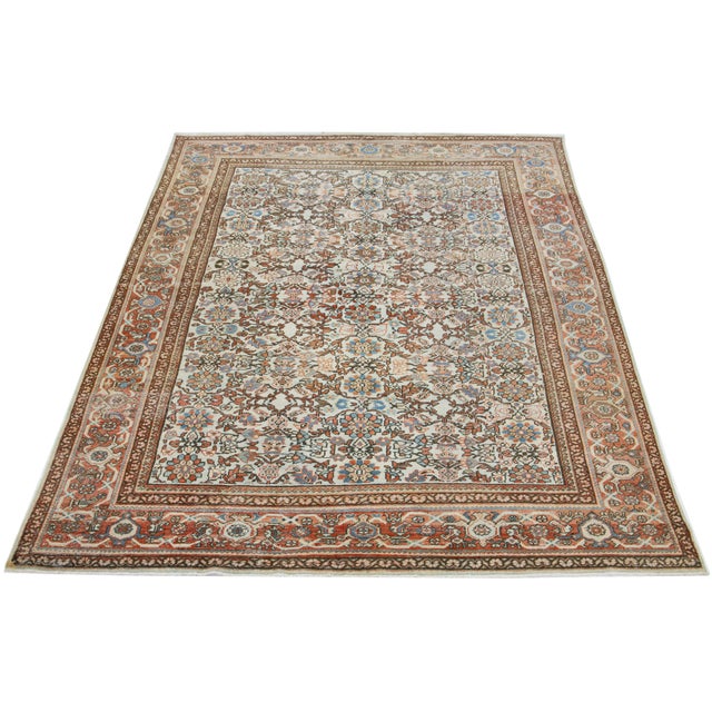 This vintage Persian Mahal wool rug features a beige background and multicolored floral designs. This rug measures 8'11" x...