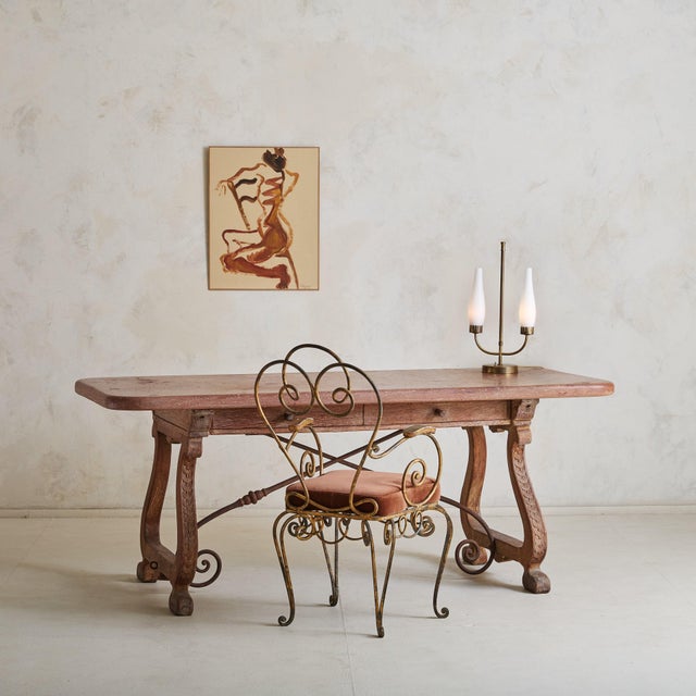 A 1950s Italian table lamp with a slender, patinated brass stem that rises gracefully to support two frosted glass shades...