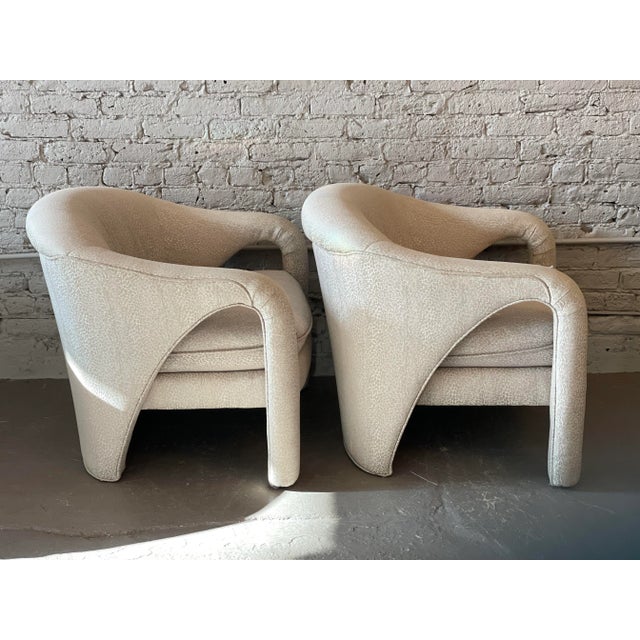 Elegant and cool sculptural lines make these chairs beautiful from all sides. There is a small tear on one chair...
