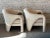 Elegant and cool sculptural lines make these chairs beautiful from all sides. There is a small tear on one chair...