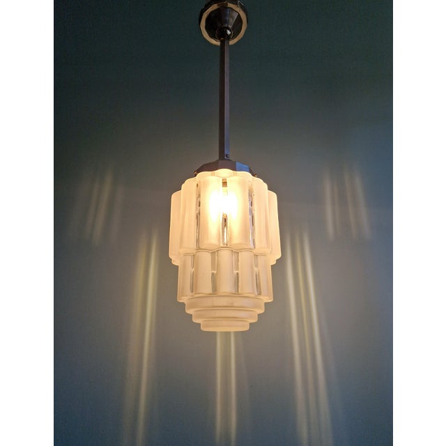 Art Deco Skyscraper pendant light in frosted clear glass with its original chrome-plated metal frame, 1930s. The pendant...