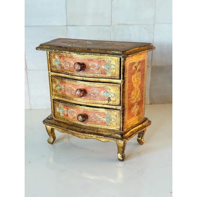 The most darling vintage Florentine jewelry box chest of drawers in shades of peach and mint with the classic gilt...