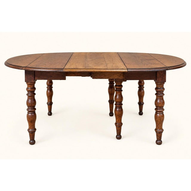 A majestic Louis-Philippe style solid oak dining table dating from the 19th century. Its circular top extends thanks to a...