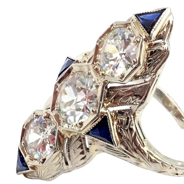 This vintage estate Art Deco ring features intricate 20k white gold filigree, set with three old miner cut diamonds...