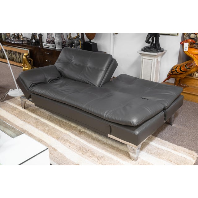 A contemporary modern sleeper sofa. This lovely contemporary sofa features a chrome frame and a soft gray leather...