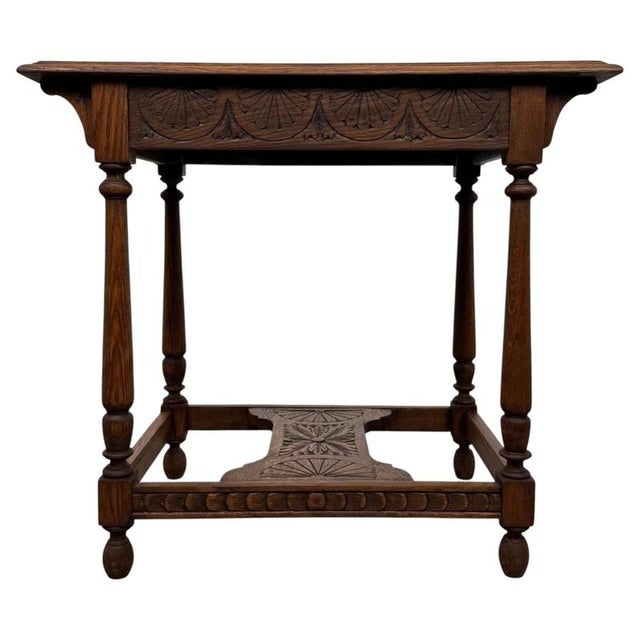 A handsome 19th-century English side table, finely crafted from oak and distinguished by its extensive carved decoration,...